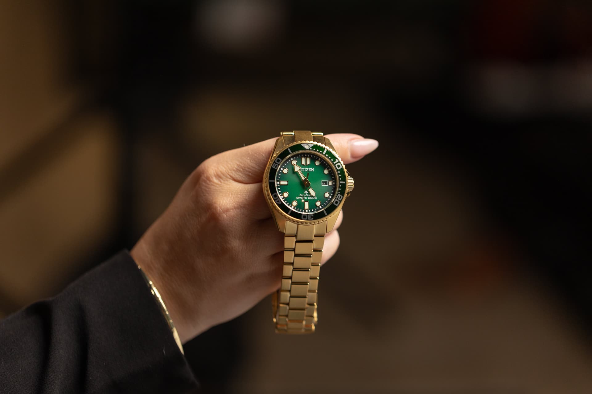 Close-up of a Citizen men’s gold-tone sports watch with green face