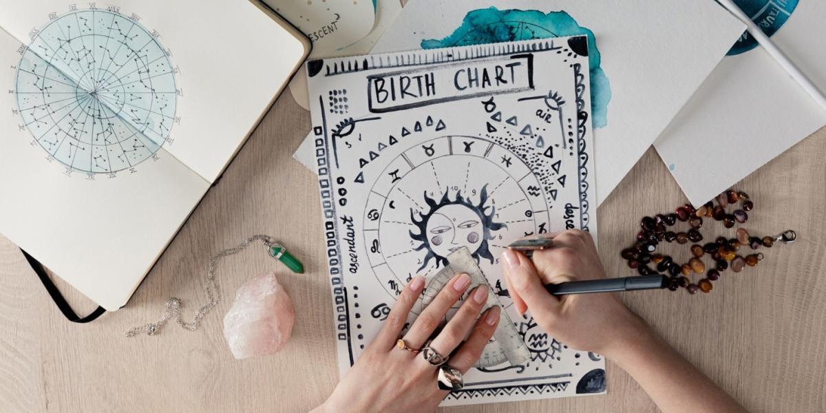 Top view of an astrologer painting a birth chart.