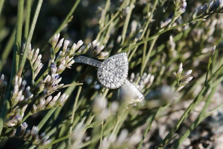 Close up of Glacier Fire mystere ring with greenery background