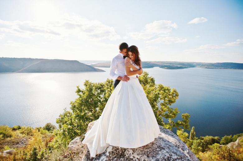 bride and groom embracing on a clifftop