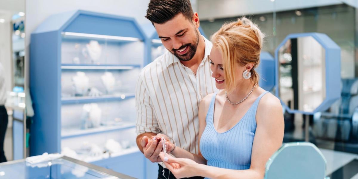 A young couple is deciding on jewellery pieces at the store.